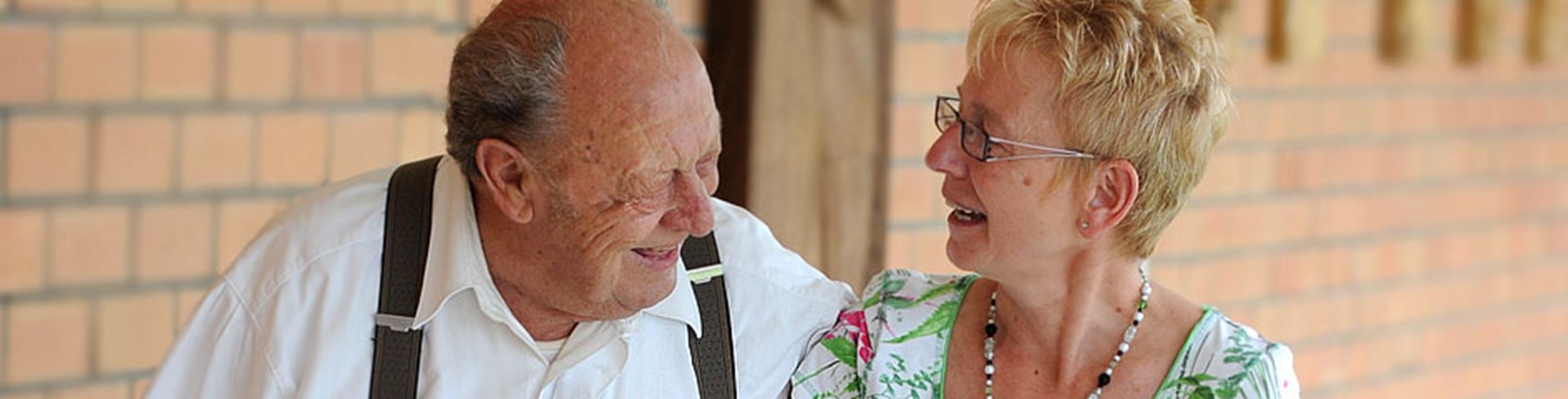 Ehrenamtliche lacht mit einem älteren Herrn